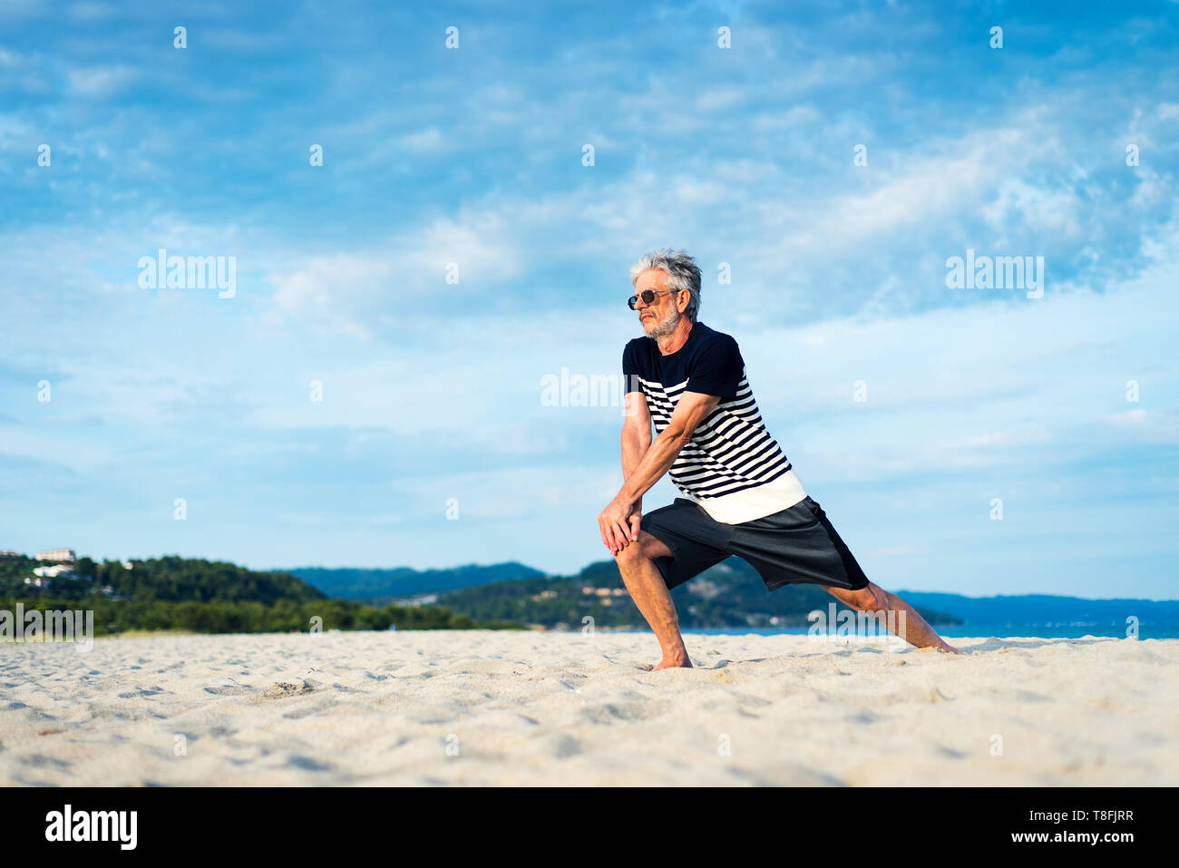 Senior man exercising on the beach, healthy lifestyle Stock Photo