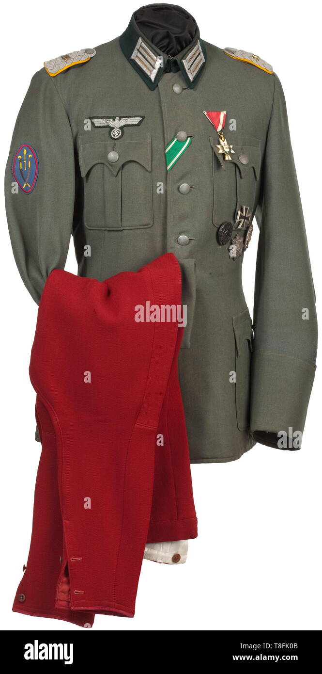 A field uniform for a Major and staff member of the Cossack Division Made to measure by the Vienna master tailor Josef Andrysek in field-grey gabardine with dark green collar, field grey buttons and matte silver insignia. Sleeve badge of the personal staff of General von Pannwitz, the large curved pocket flaps in traditional Austrian style. Green stitched silk liner with corresponding tailor's tag, the inner pocket with a fadede name tag. A coat used over a long period of time, with corresponding age patina. Breeches of madder red gabardine (drag, Additional-Rights-Clearance-Info-Not-Available Stock Photo