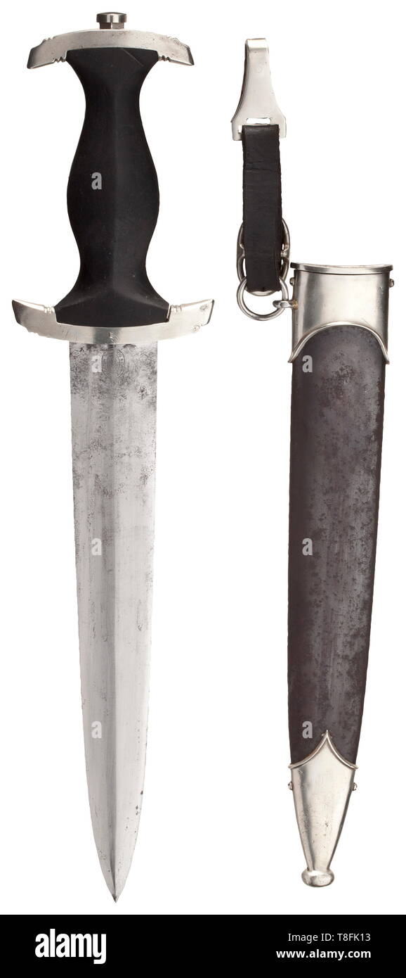 A SS honour dagger M 34 with removed dedication The blade etched on the obverse side with the motto 'Meine Ehre heißt Treue'(My Honour is Loyalty), and on the reverse with the 'Carl Eickhorn Solingen' and signs of the removed dedication. Black wooden grip with inlaid emblems. The nickel-silver crossguard marked 'I' on the side. Rust-coated iron scabbard with remnants of the black finish and nickel-silver mounts. Leather hanger. Traces of age and usage. Length ca. 37 cm. Rare dagger. historic, historical, 20th century, 1930s, 1940s, Waffen-SS, armed division of the SS, armed, Editorial-Use-Only Stock Photo