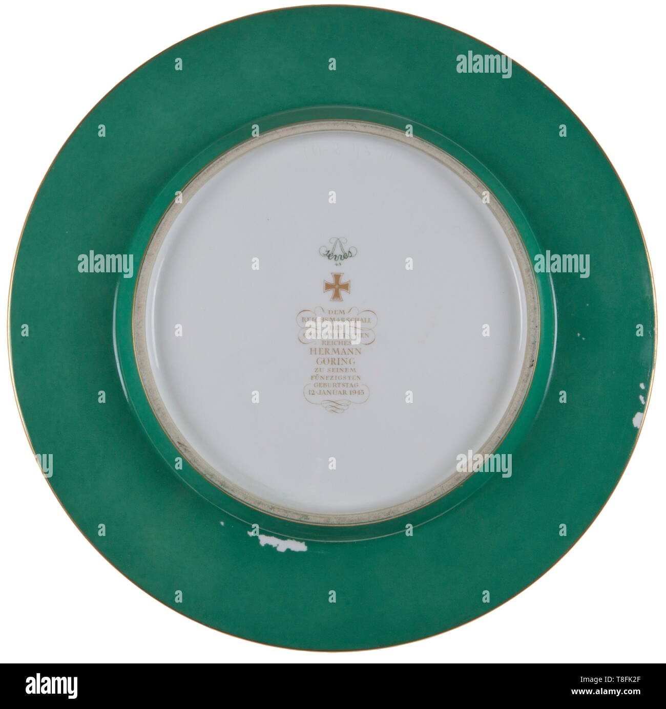 Hermann Göring - a large trophy plate from the SÃ¨vres presentation service presented to him on occasion of his 50th birthday on 12 January 1943. White porcelain with the gold great coat of arms of the Göring family in centre bordered by yellow, green glazed border with rich gold oak leaf decoration and rim. Two medallions, one with a hand-painted deer trophy, other with text 'BASEDOW 22 October 1938'. Reverse bottom bears 1943 SÃ¨vres manufacture's mark in underglaze green and an overglaze golden dedication, 'Dem Reichsmarschall des Grossdeutschen Reiches Hermann Göring zu, Editorial-Use-Only Stock Photo