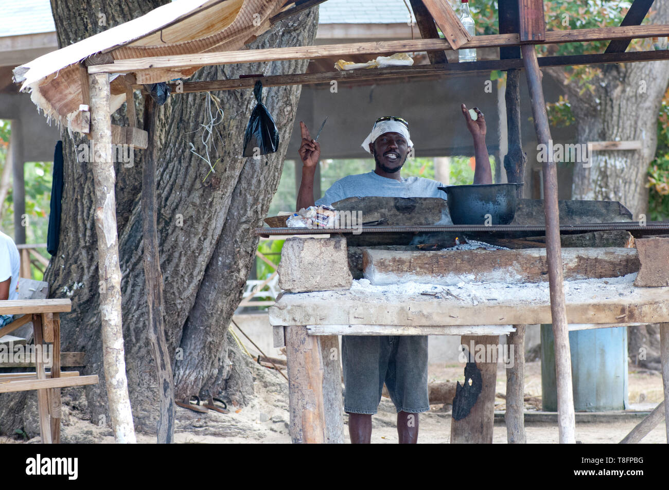 Jamaican man cooking food in pots at a beach front cafe Stock Photo Alamy