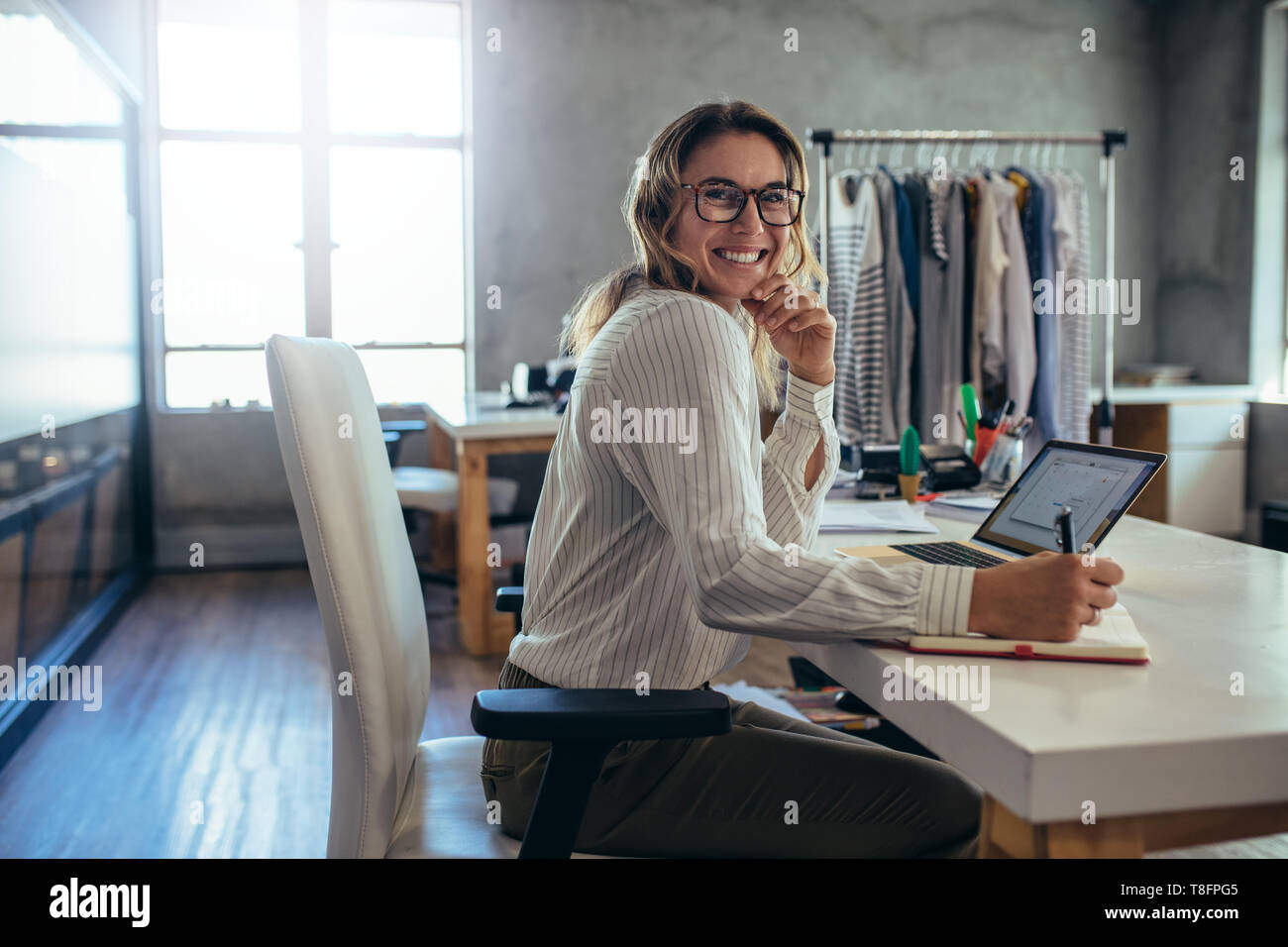 Caucasian online seller businesswoman working at office. Female entrepreneur taking online orders. Stock Photo