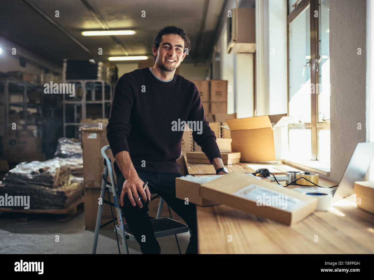 Confident young businessman working at online business store. Small business owner at his work desk. Stock Photo