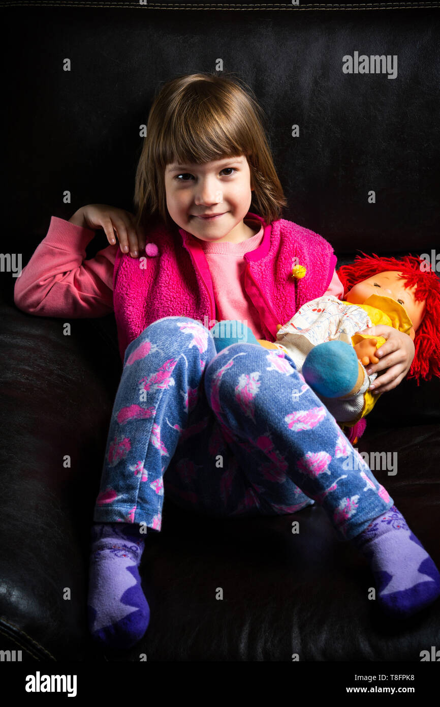 Cute girl with her toy on the sofa at home Stock Photo - Alamy