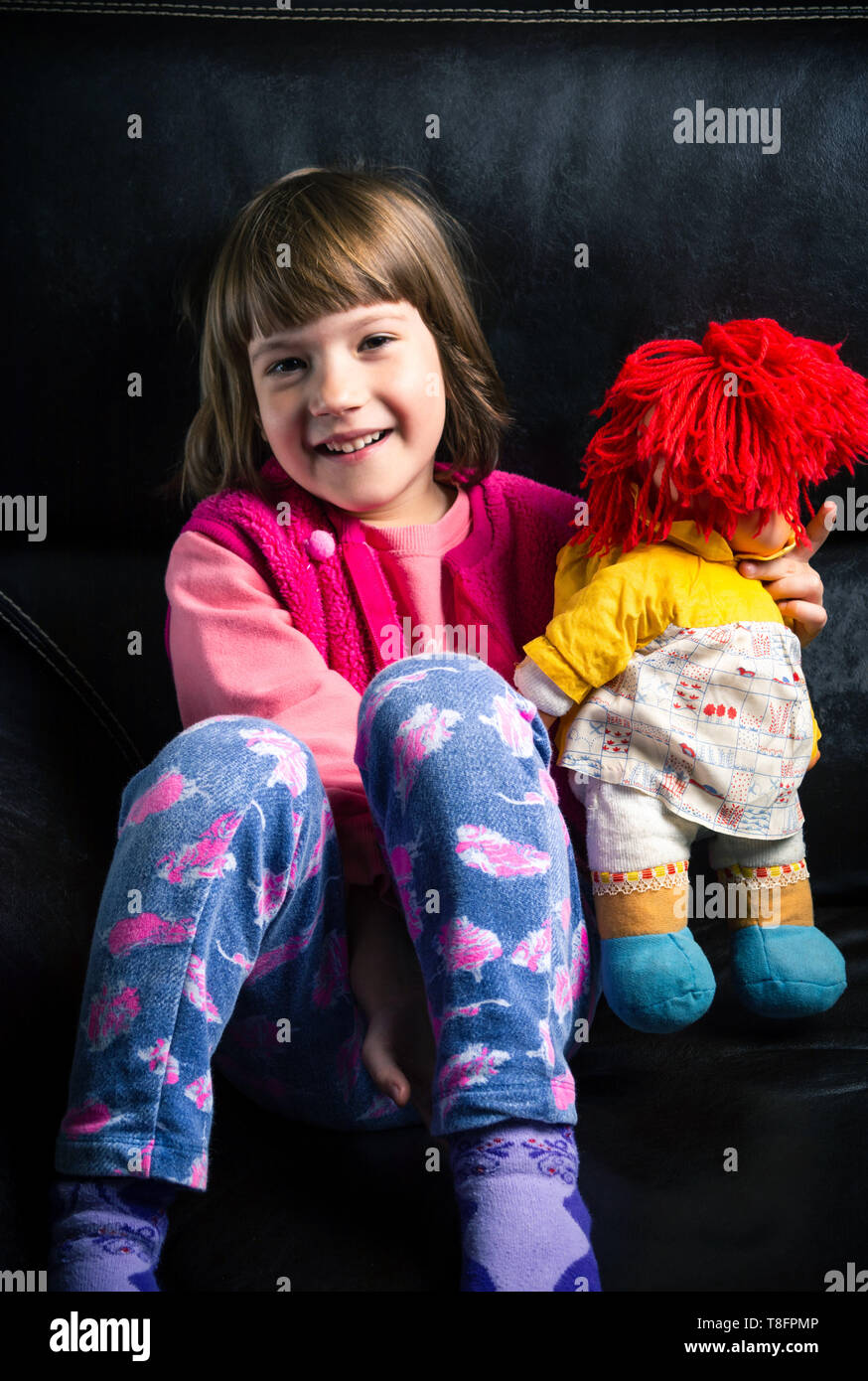 Cute girl with her toy on the sofa at home Stock Photo - Alamy