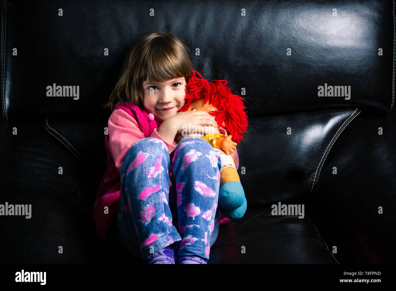 Cute girl with her toy on the sofa at home Stock Photo - Alamy