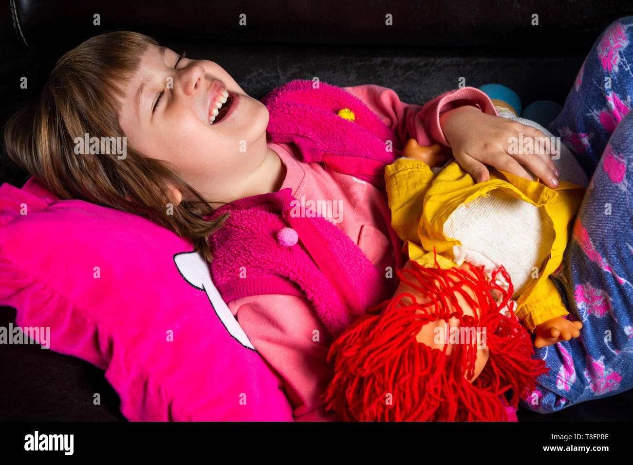 Cute girl with her toy on the sofa at home Stock Photo - Alamy