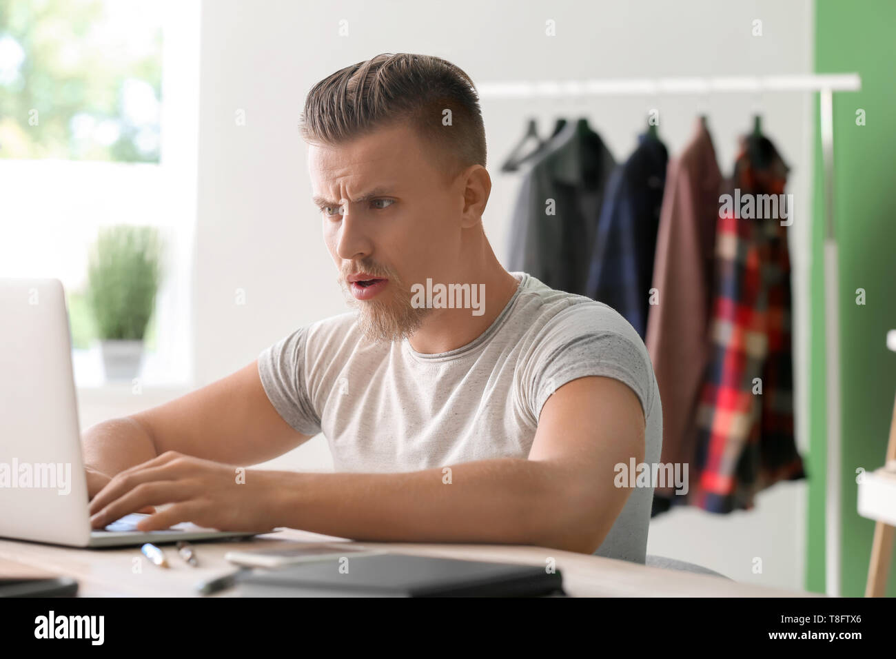 Troubled freelancer working on laptop at home Stock Photo