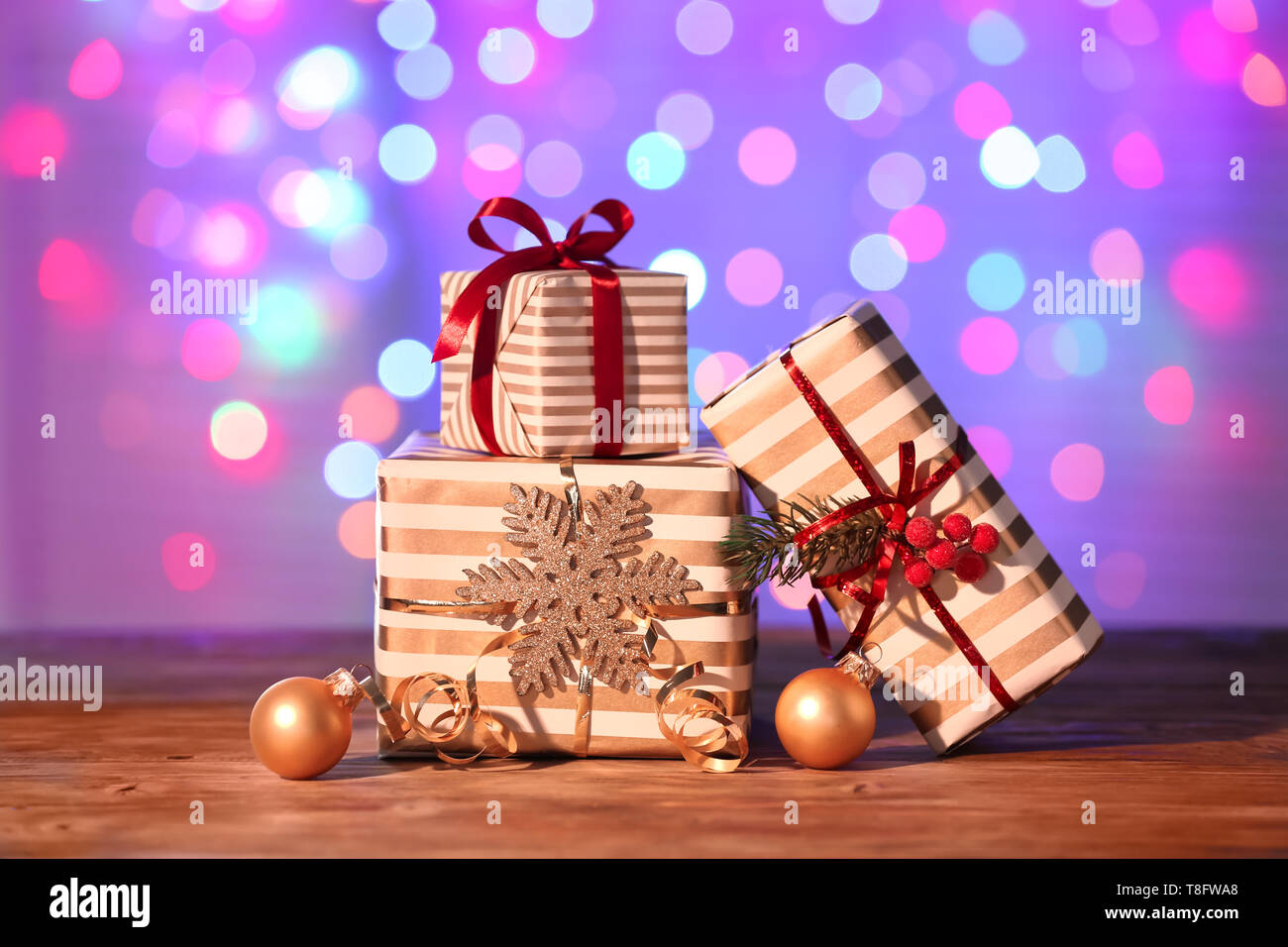 Beautiful Christmas gift boxes with decorations on table against