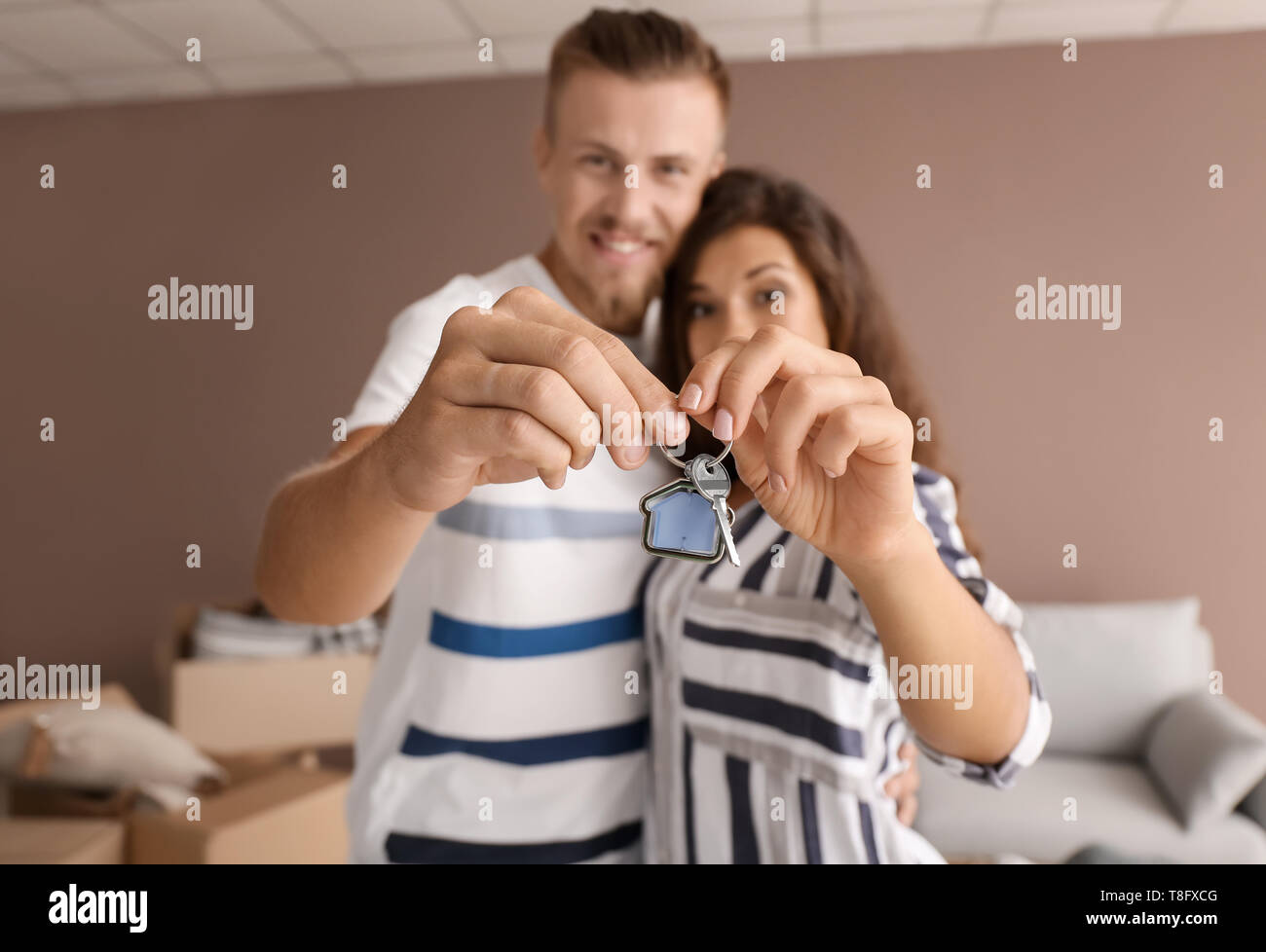 Happy young couple with key from their new house indoors Stock Photo ...