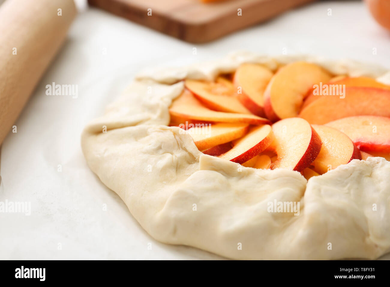 Raw peach galette on table, closeup Stock Photo