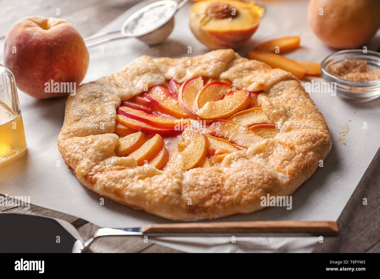 Parchment with delicious peach galette on table Stock Photo