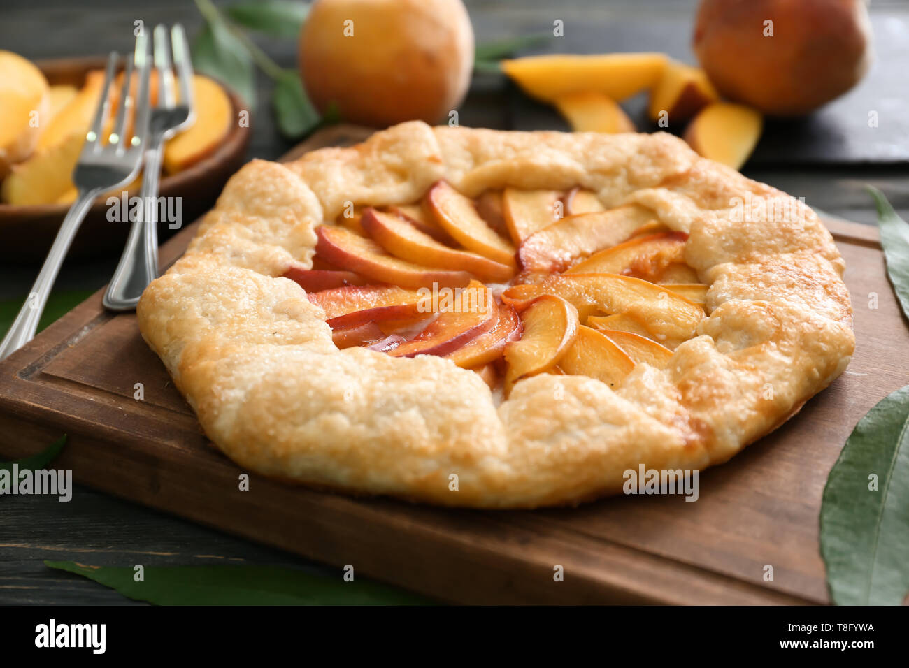 Delicious peach galette on wooden board Stock Photo