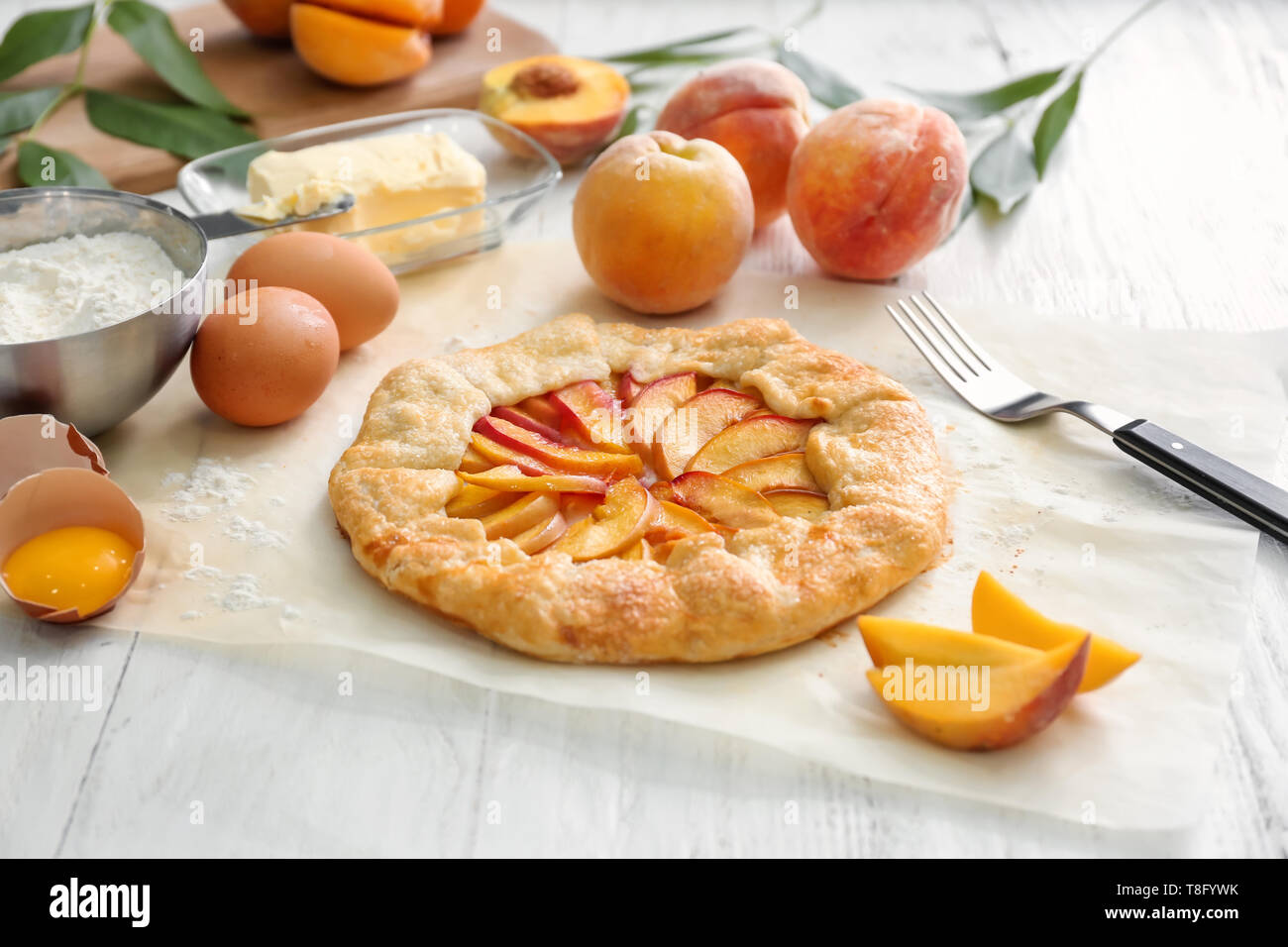 Parchment with delicious peach galette on white table Stock Photo