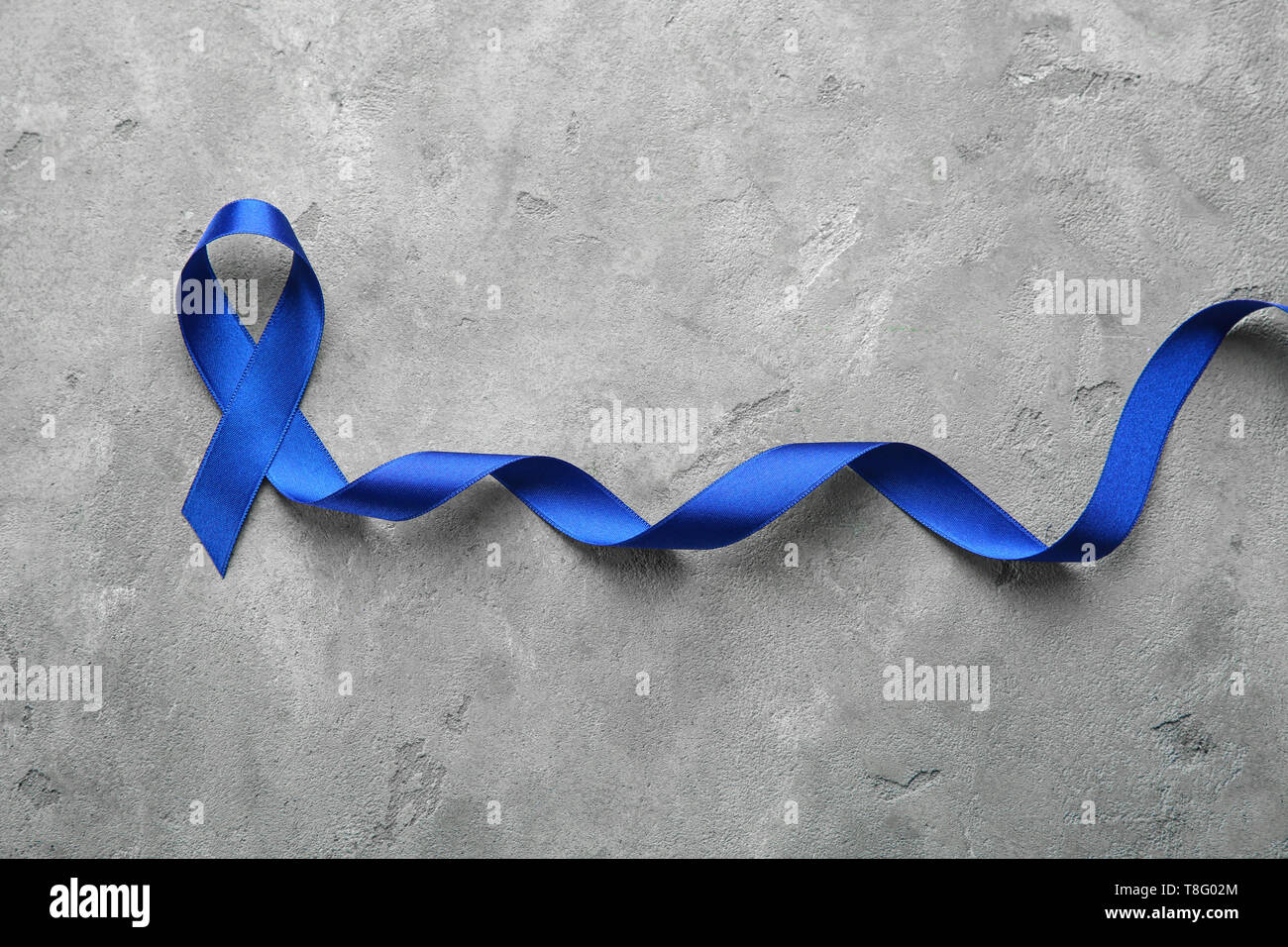 Blue ribbon on grey background. Cancer concept Stock Photo - Alamy
