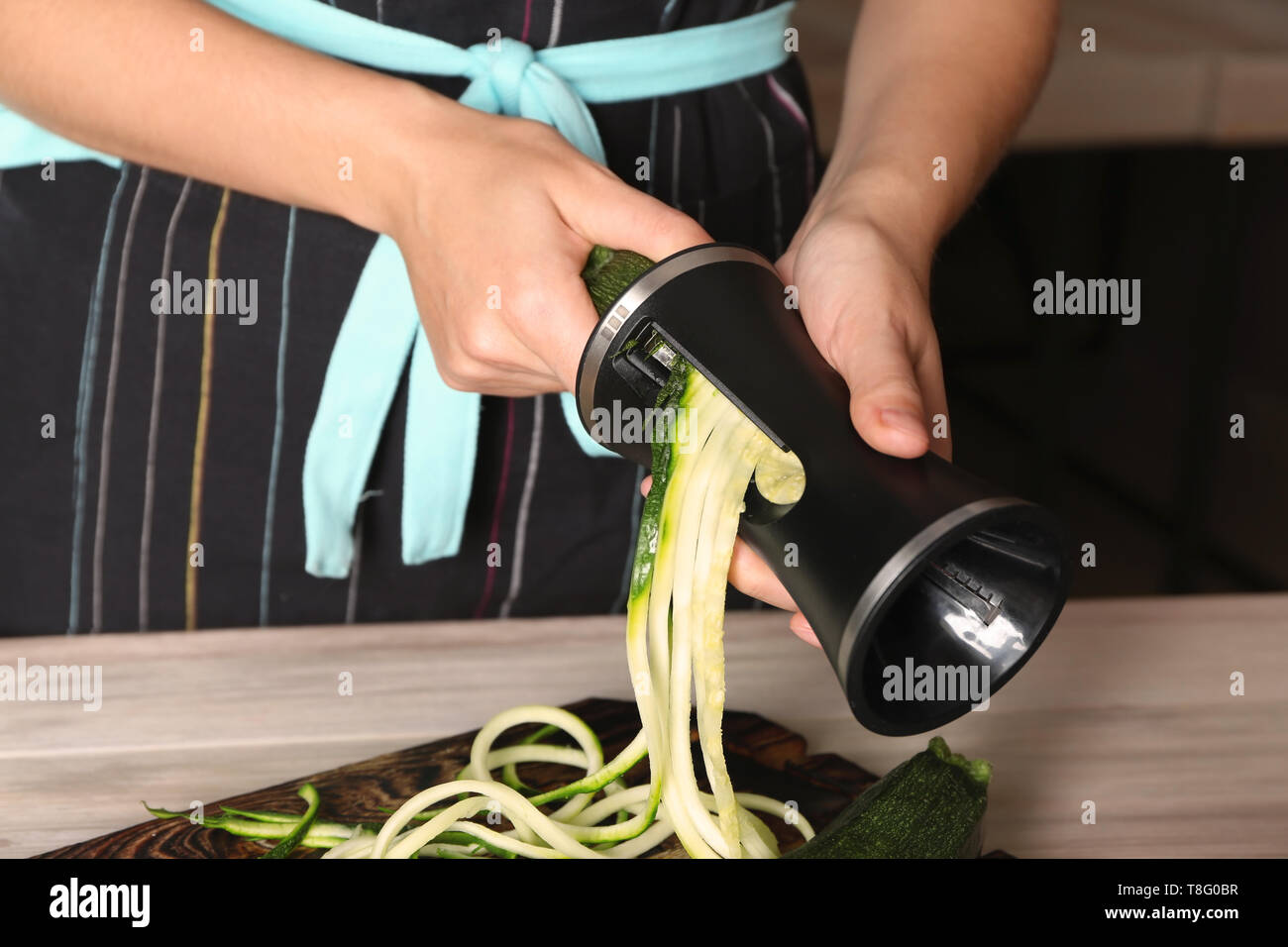 Woman making zucchini spaghetti, closeup Stock Photo