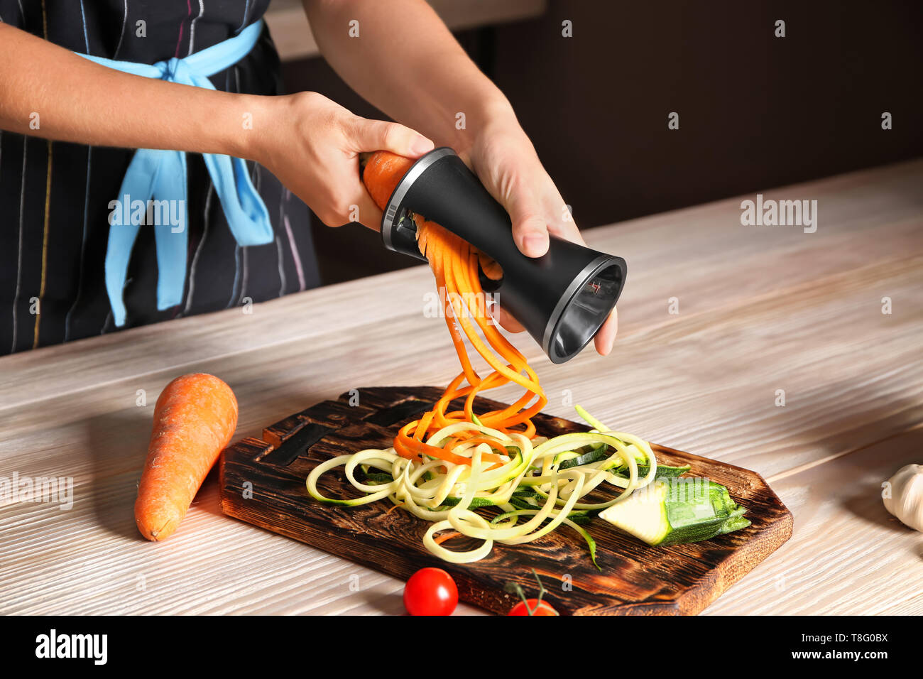 Woman making zucchini and carrot spaghetti Stock Photo