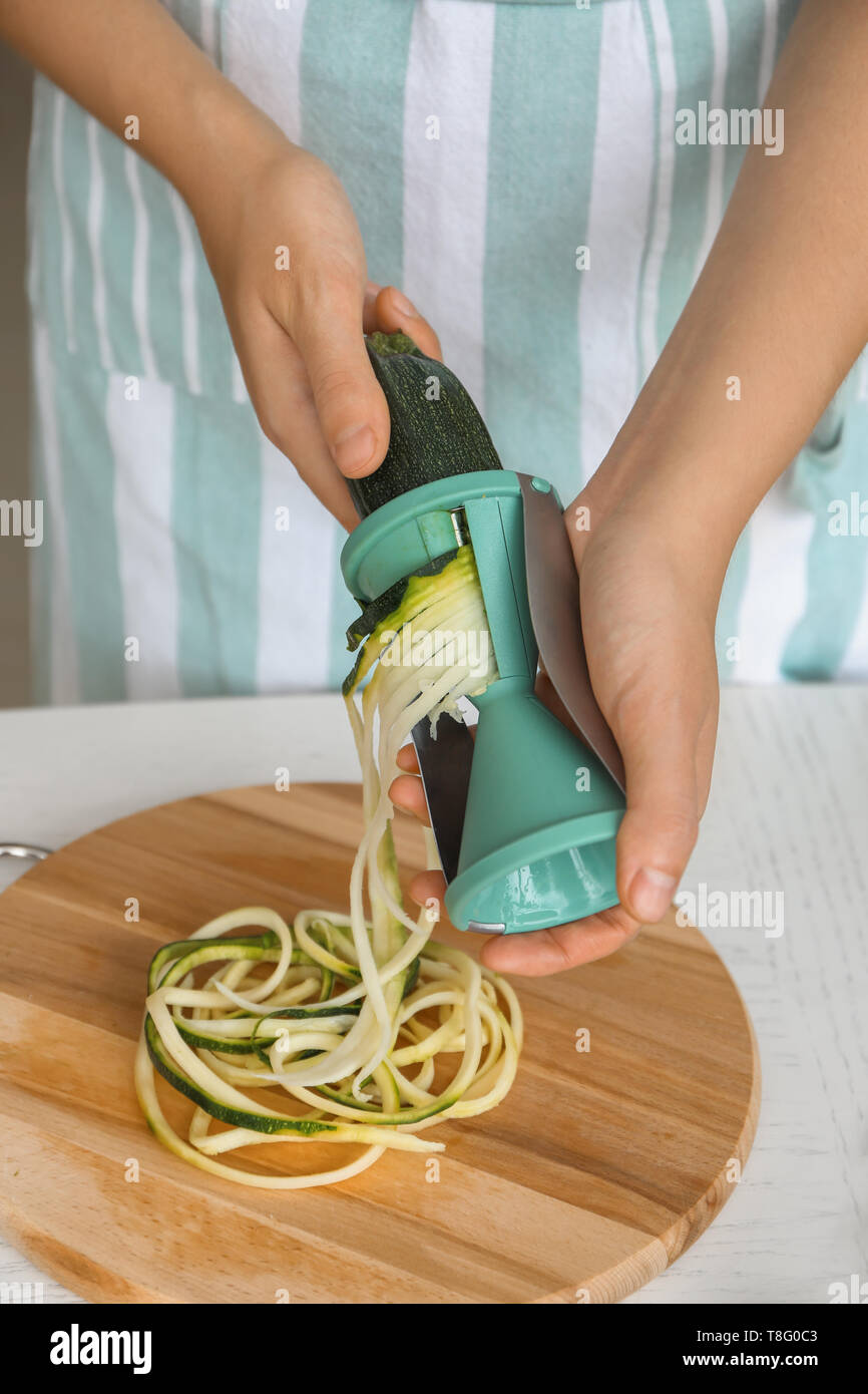 Woman making zucchini spaghetti, closeup Stock Photo