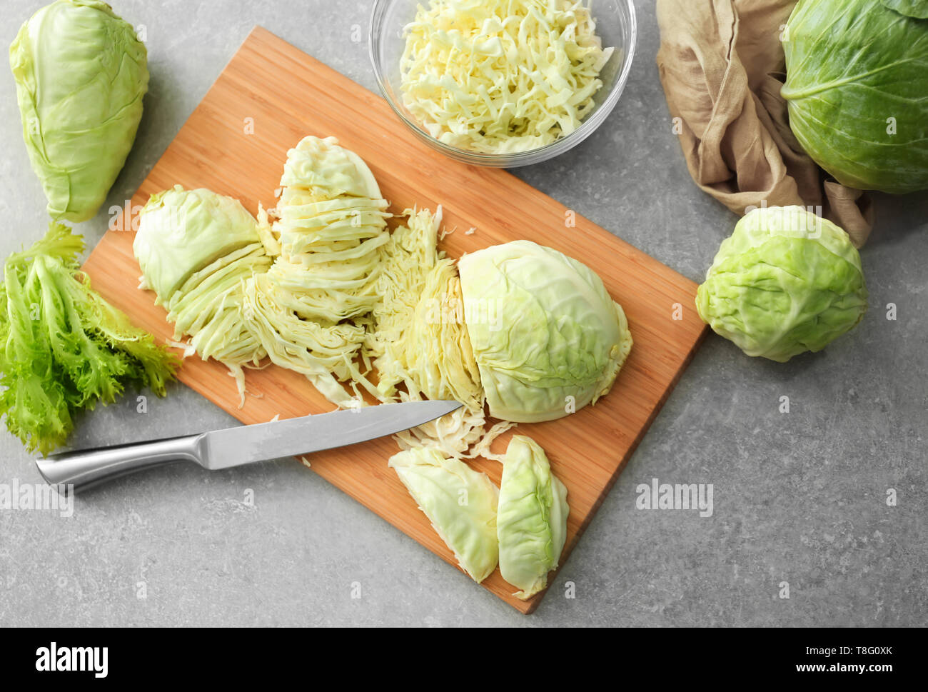 Wooden board with cut cabbage on table Stock Photo - Alamy