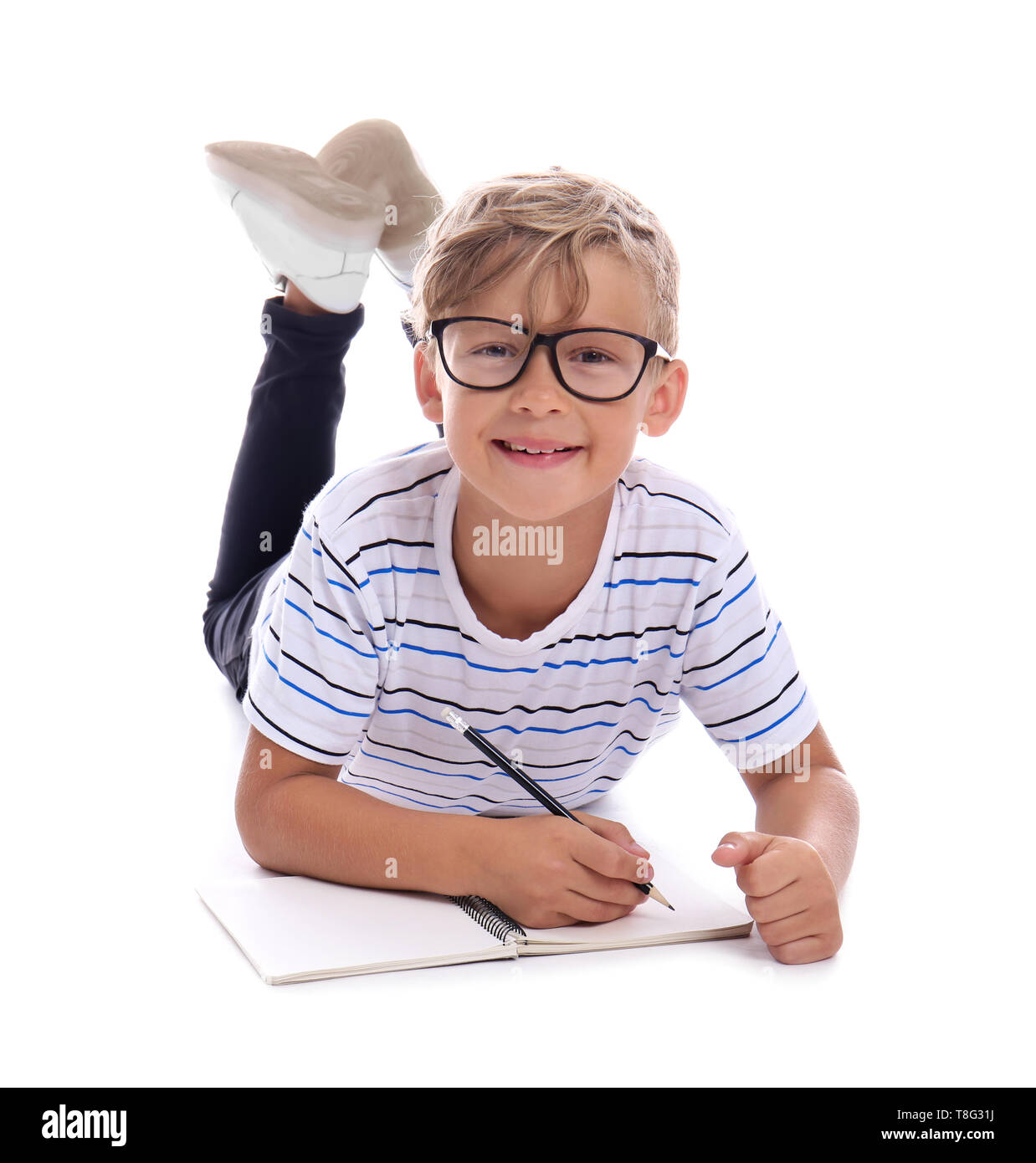 Cute little schoolboy doing homework on white background Stock Photo