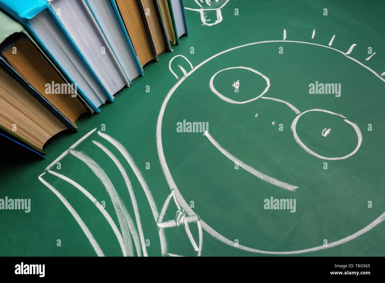 Stack of books and drawn schoolboy on chalkboard Stock Photo - Alamy