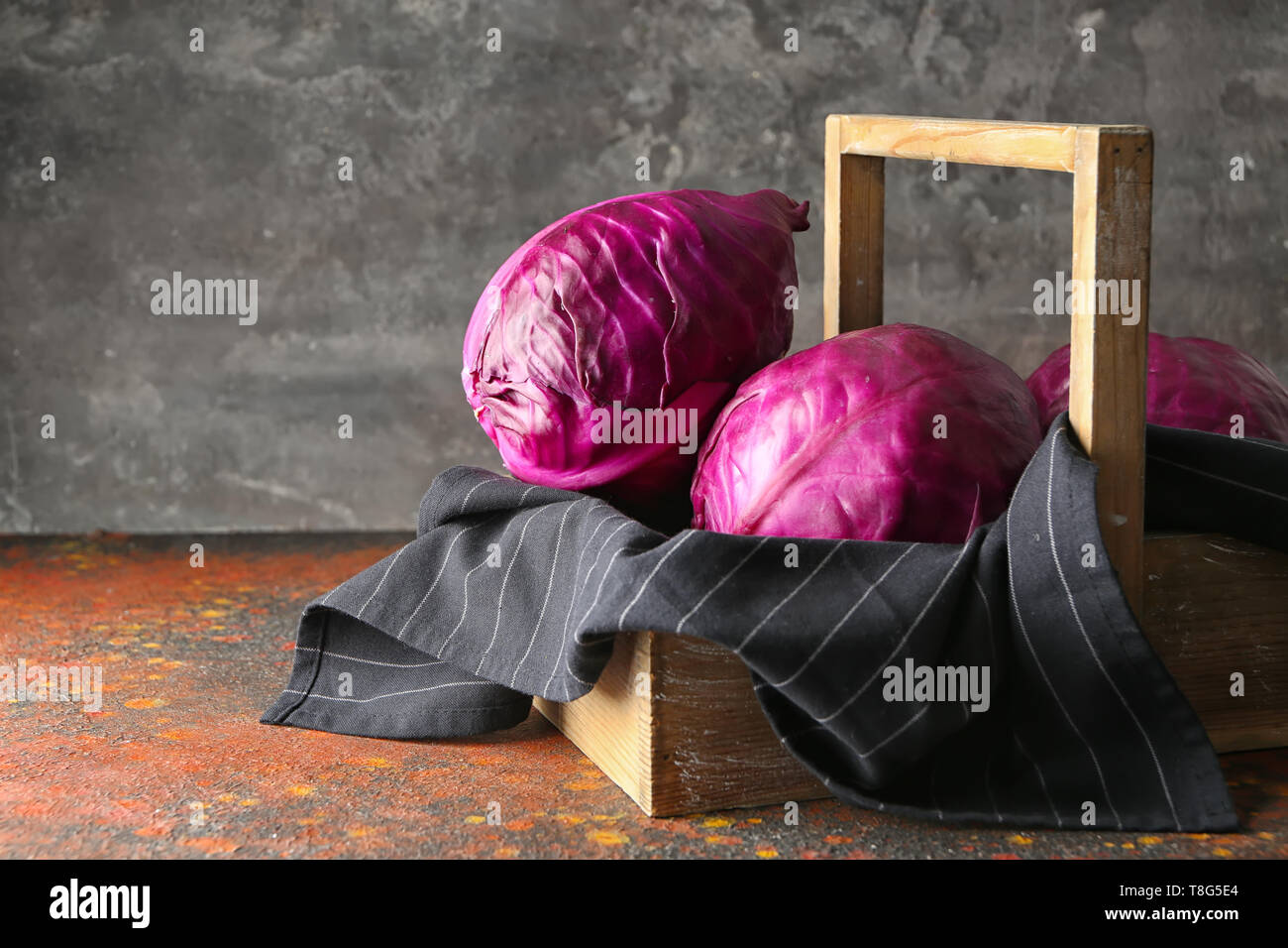 Crate with ripe red cabbage on color table Stock Photo - Alamy