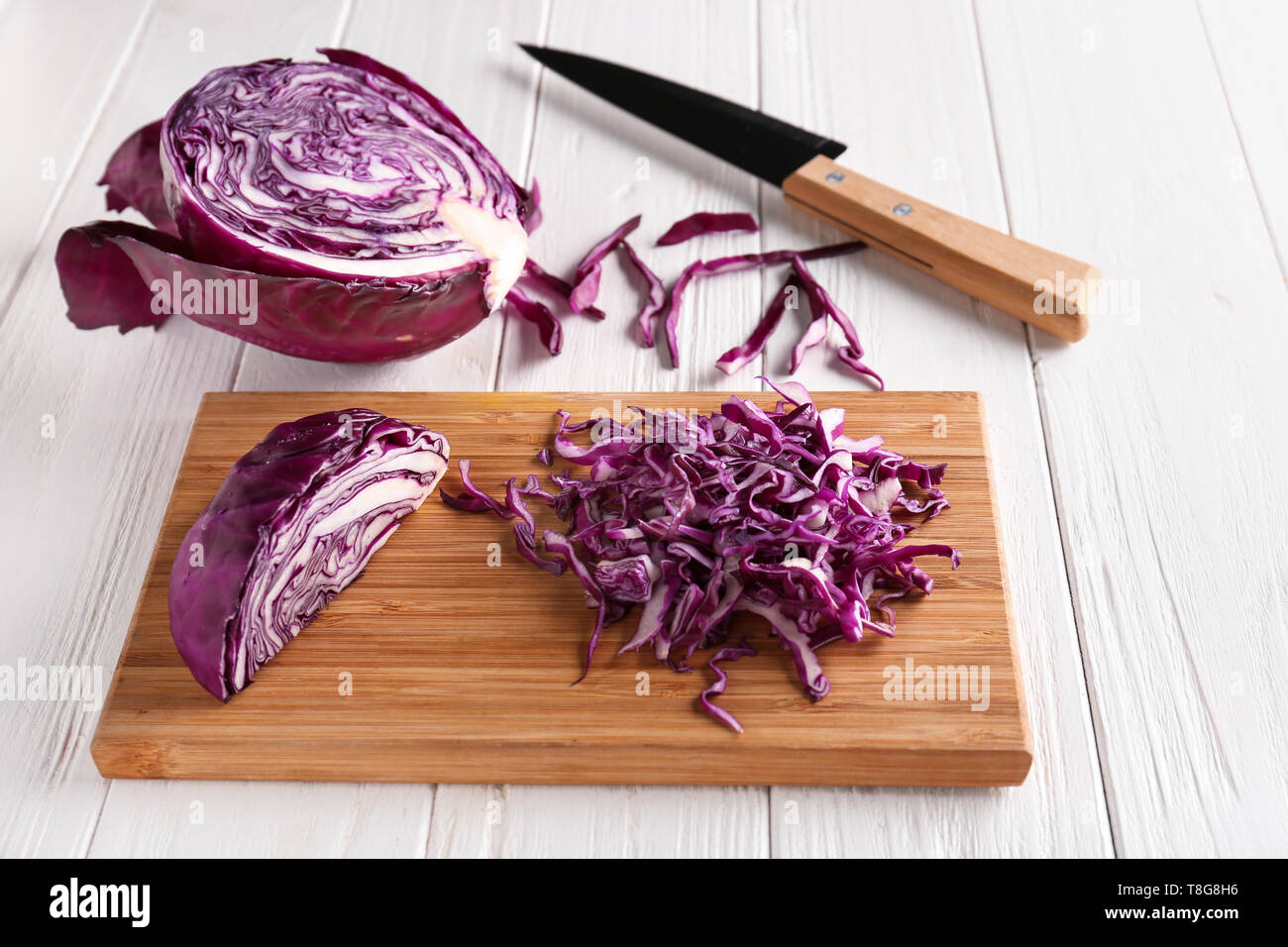 Board with chopped red cabbage on white wooden table Stock Photo - Alamy