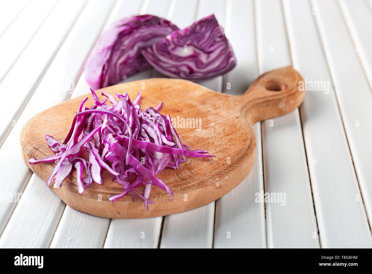Board with chopped red cabbage on white wooden table Stock Photo - Alamy