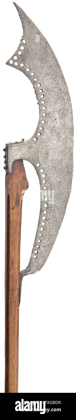 A Russian bardische 17th/18th century. The head formed as a long flat knife-like blade with convex cutting edge, the base drawn out to a flattened prong attached to the haft, pierced with two series of circular holes following the strongly dished contours of the back edges, the latter additionally decorated with small panels of cusped ornament in the upper half, and short socket retained by four nails along the back and an iron cap nailed over the top: on its original faceted wooden haft, flattened and widening below the socket and carved with a , Additional-Rights-Clearance-Info-Not-Available Stock Photo