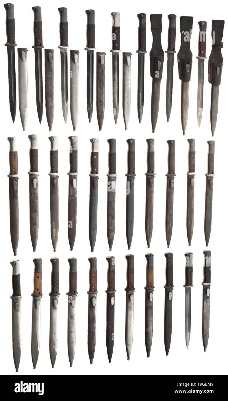 30 bayonets M 84/98 No matching numbers, complete with sheaths. Manufacturer (partly coded) e. g. W.K.C, P. Weyersberg, Hörster, Heller, Herder, Alcoso, Corts, Mundlos. Nine bayonets with wooden grip panels and 21 with Bakelite ones (three of them with leather frogs and one without sheath). Lightly damaged in places, traces of usage and age. Length circa 40 cm. historic, historical, accessory, accessories, miscellaneous, sundries, other, utility, utilities, equipment, utensil, piece of equipment, utensils, object, objects, stills, clipping, clipp, Additional-Rights-Clearance-Info-Not-Available Stock Photo