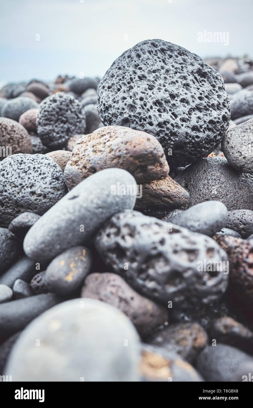 Close up picture of a volcanic rock on a beach, selective focus, color toning applied. Stock Photo