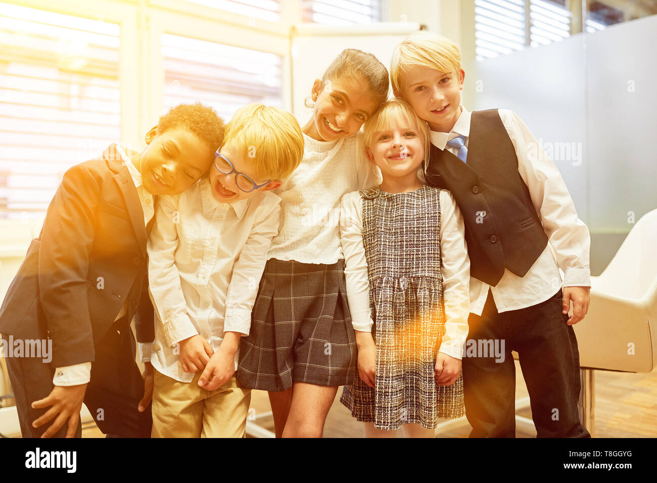 Laughing multicultural group of children as a business team in school or office Stock Photo
