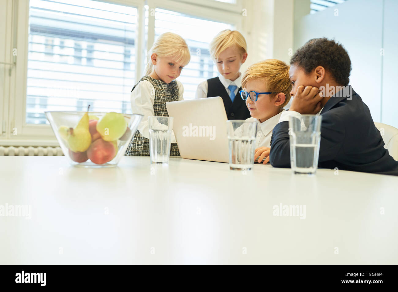 Group of kids as business team on laptop Computer at planning or e-learning Stock Photo