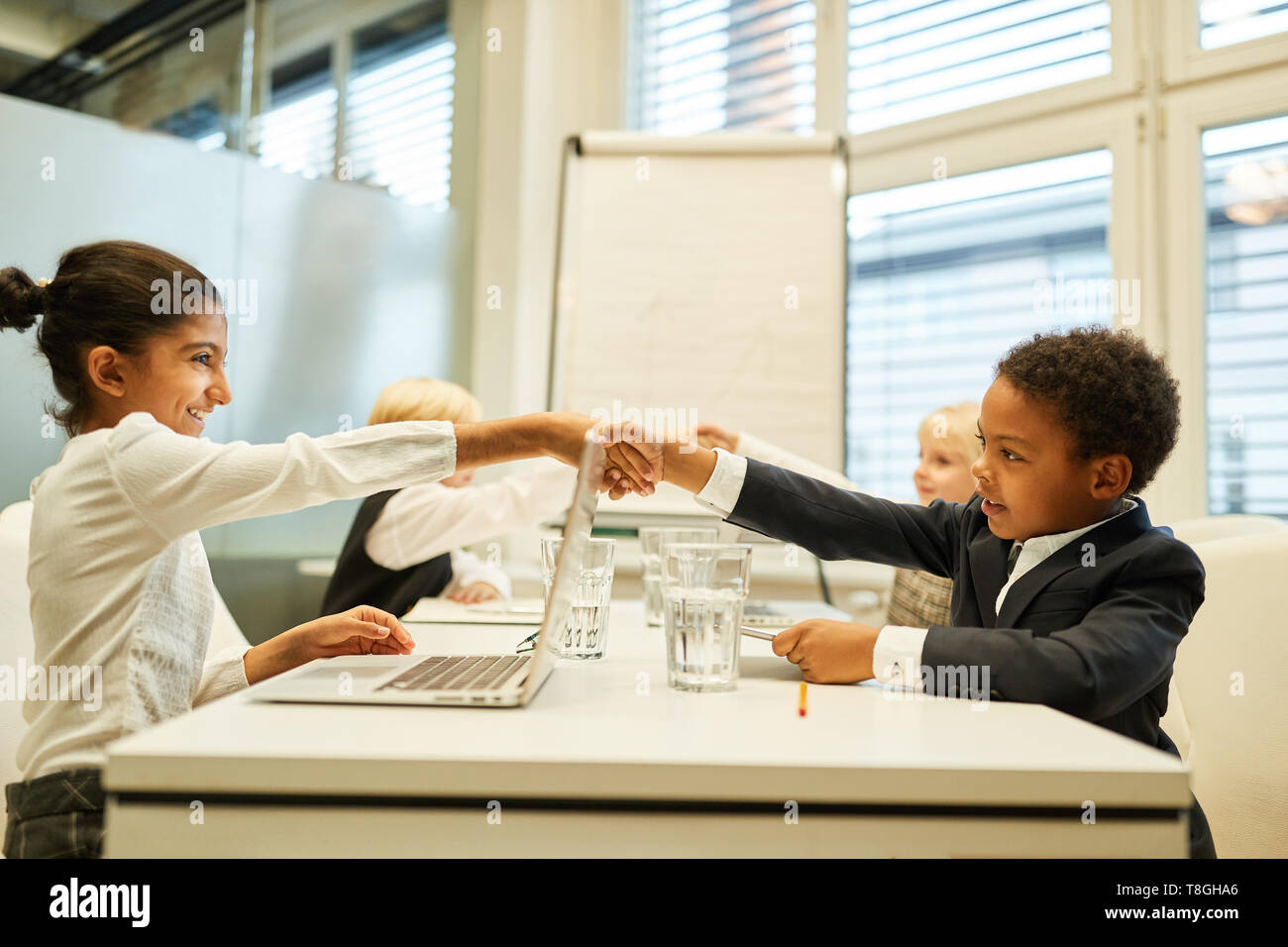 Children as businessmen greet each other with a handshake before the negotiations Stock Photo