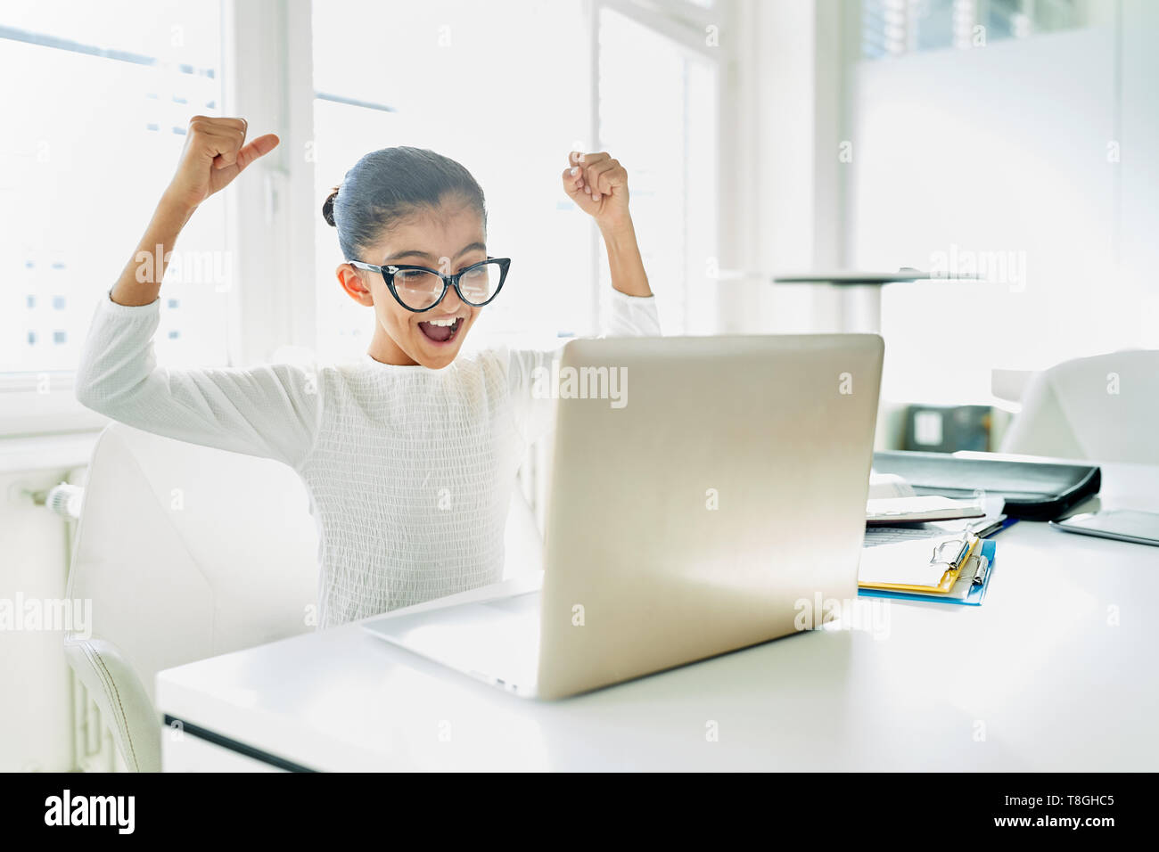 Girl as Business Woman on Laptop Computer celebrates a success Stock Photo