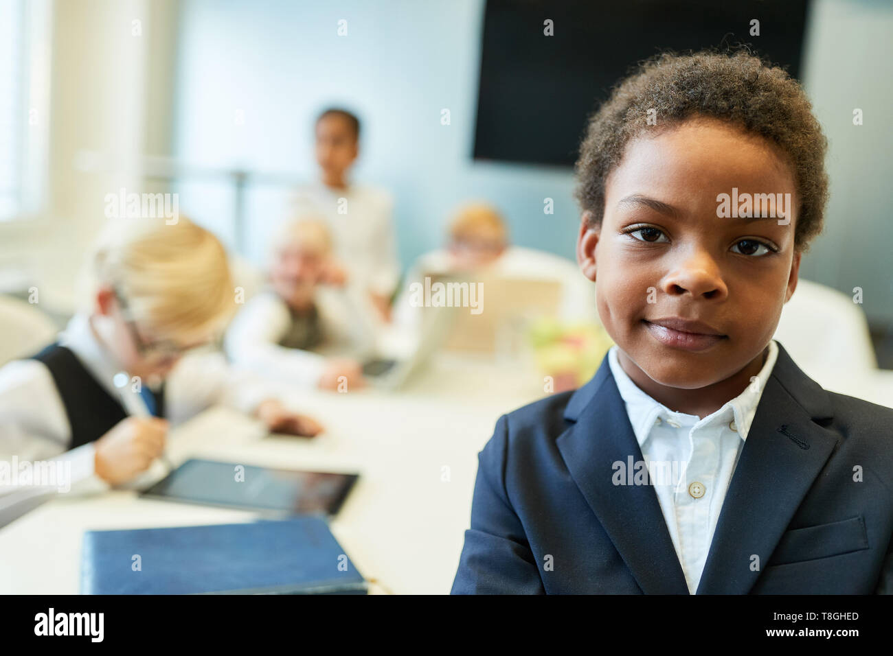 African child as a businessman or entrepreneur in front of his business team Stock Photo