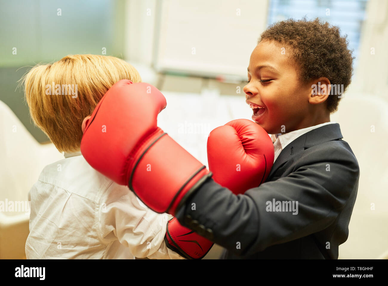 Business children in a boxing match as a role-playing game or training to reduce stress Stock Photo
