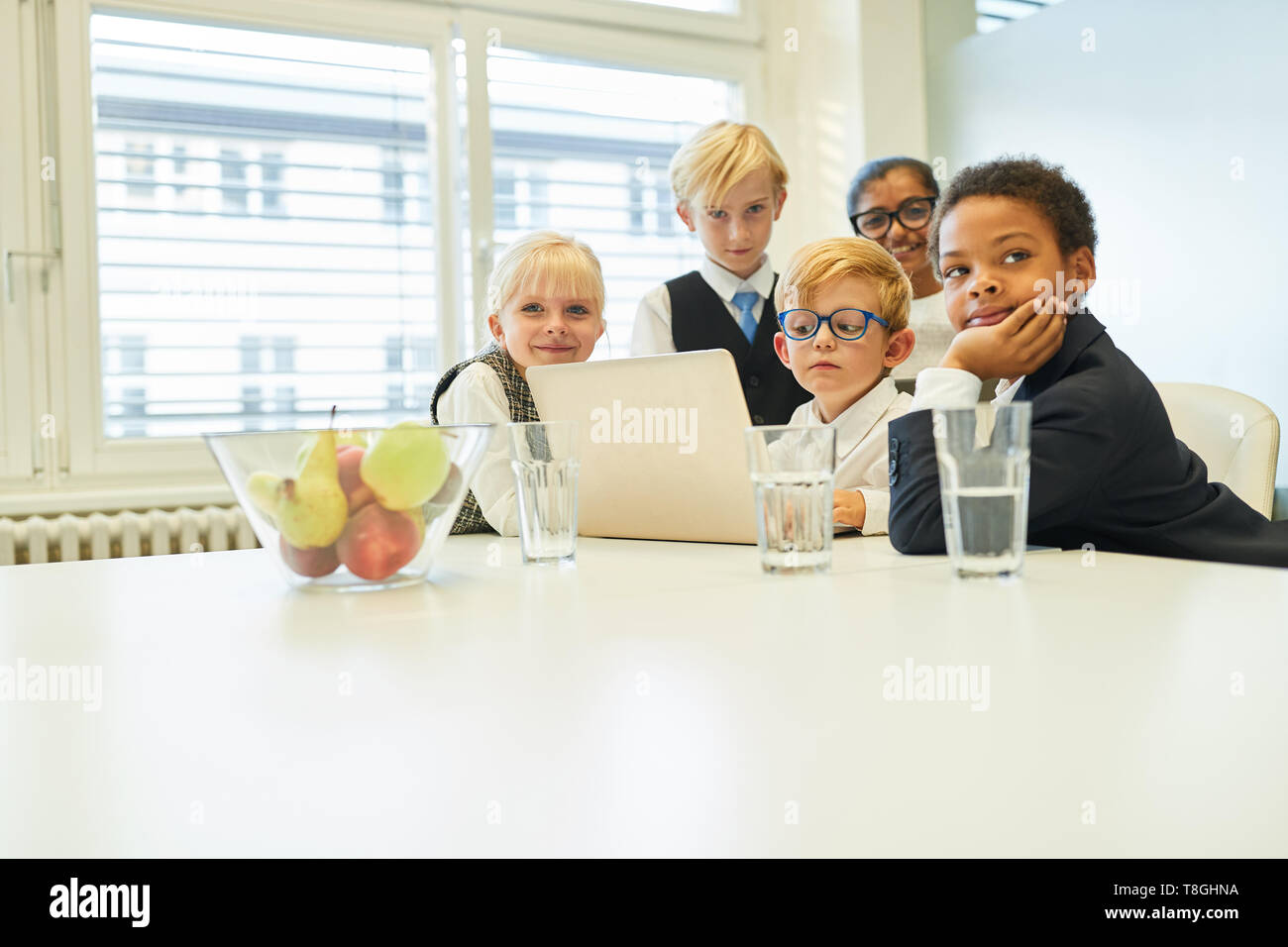 Group of kids as a business team on the internet at laptop computer Stock Photo