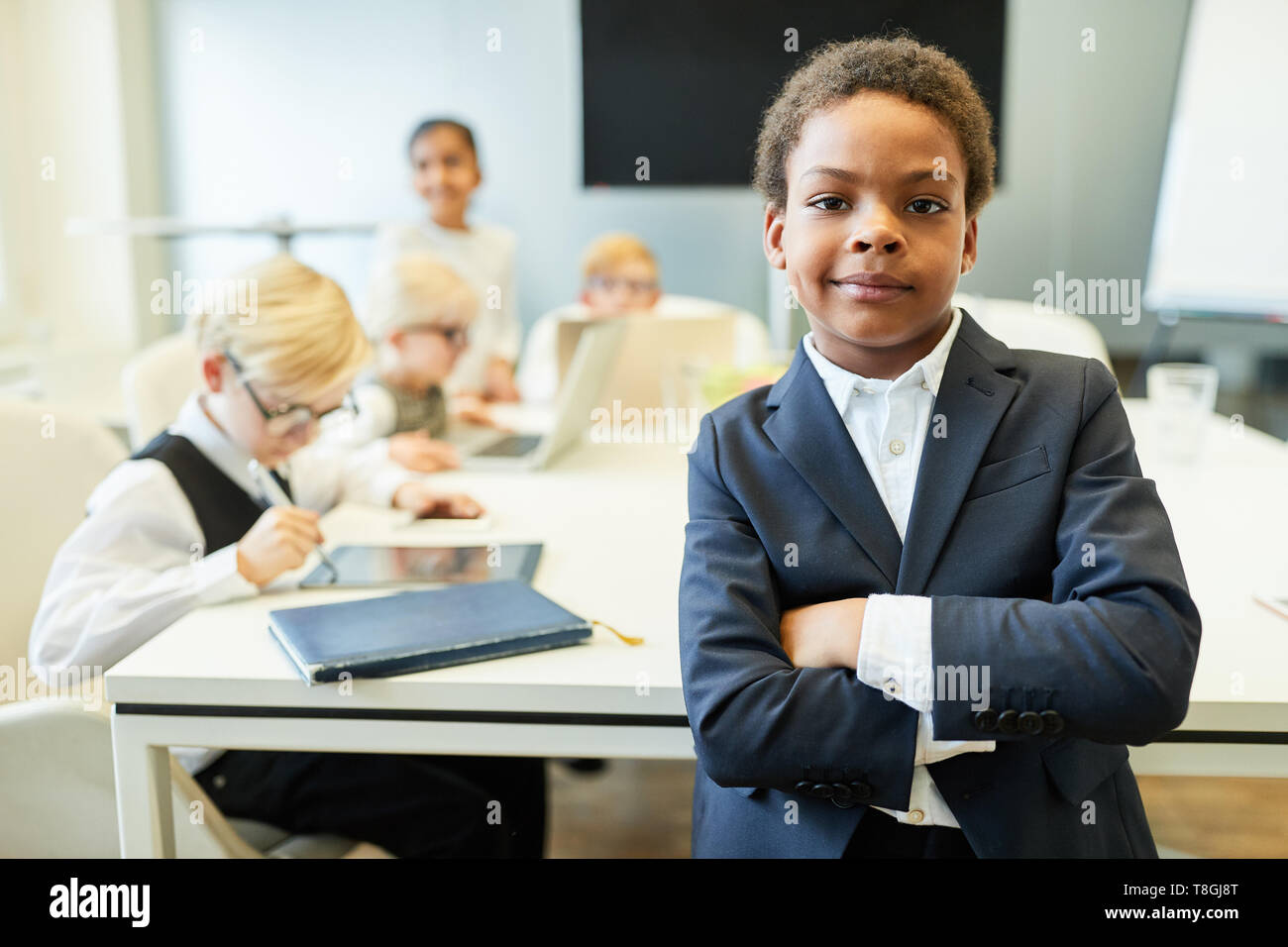 African boy as manager or consultant with crossed arms in front of team Stock Photo