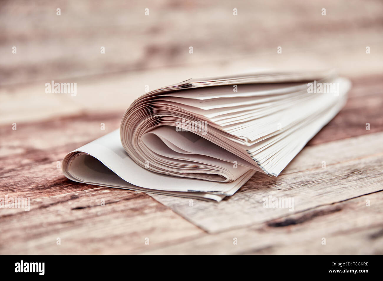 Folded newspaper and newsletter lie on a table on top of each other Stock Photo