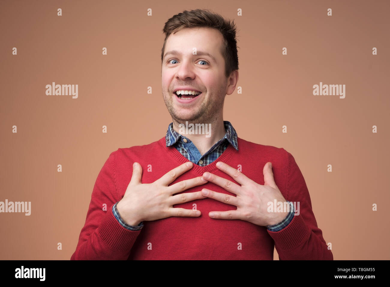 Young man being content to hear compliment Stock Photo