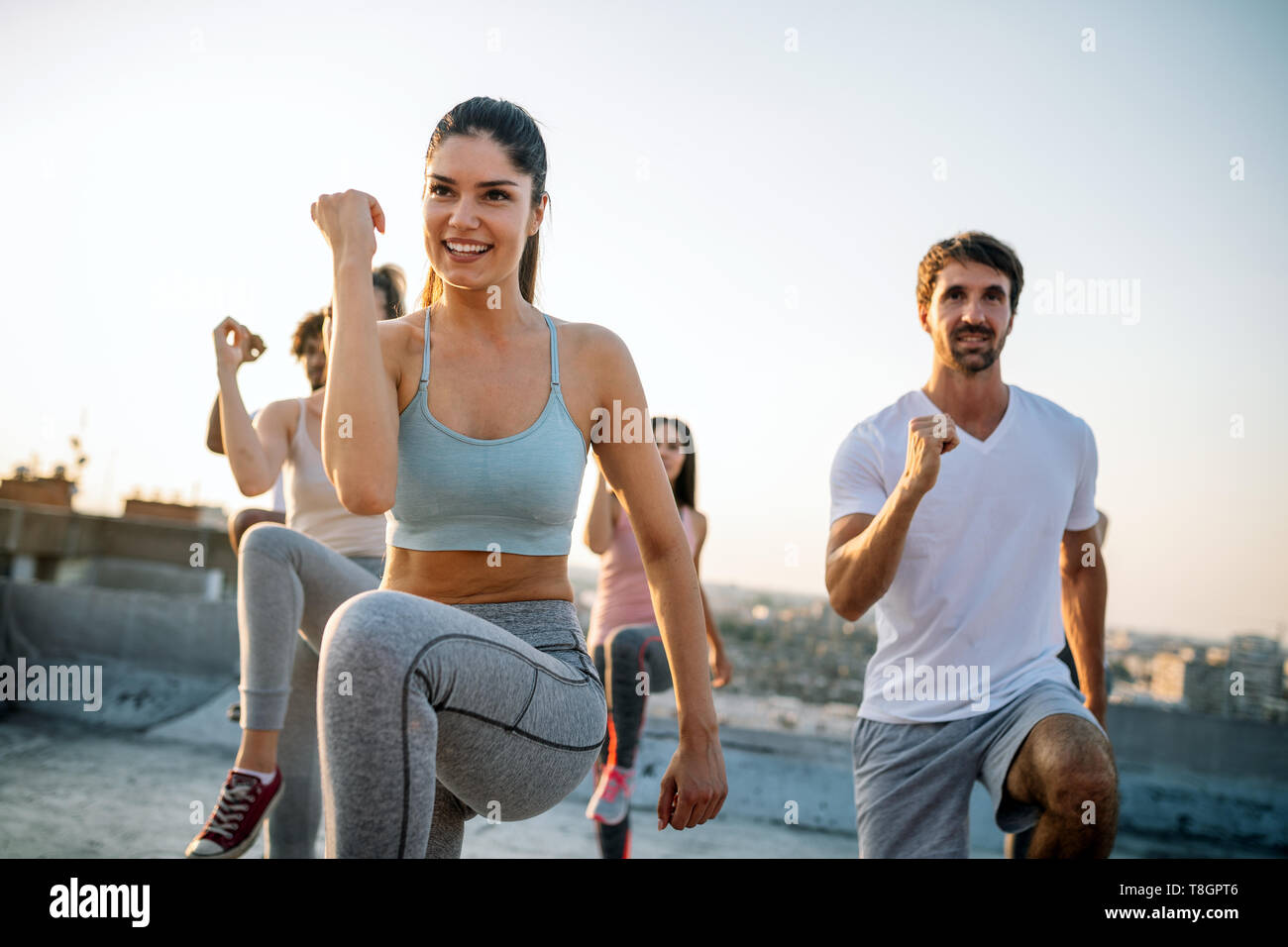 Group of happy fit friends exercising outdoor in city Stock Photo