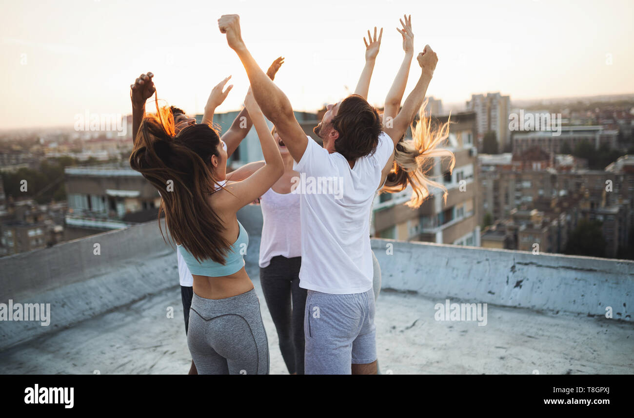 Group of happy fit friends exercising outdoor in city Stock Photo