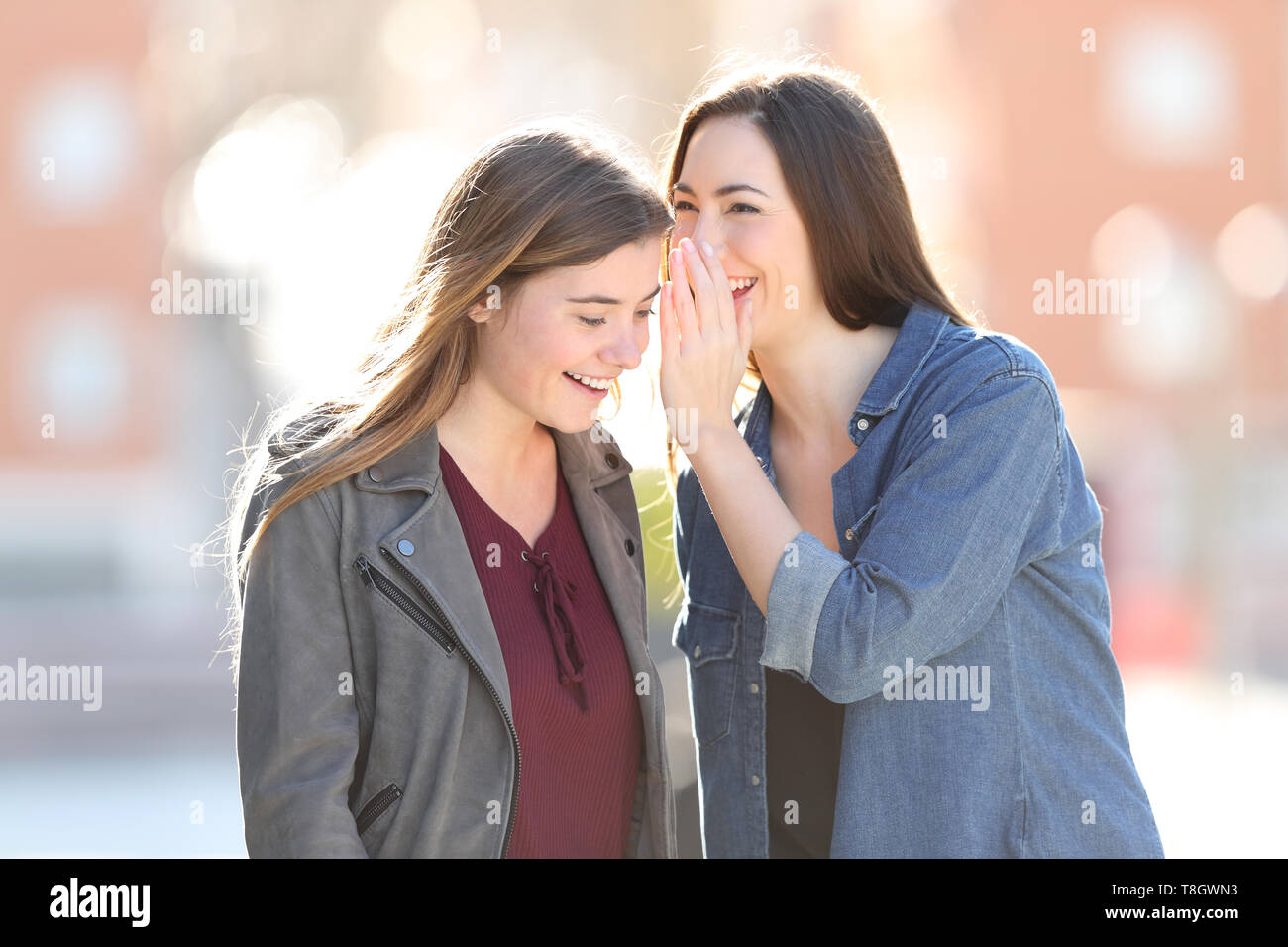 Gossip woman telling secret to her friend in the street Stock Photo