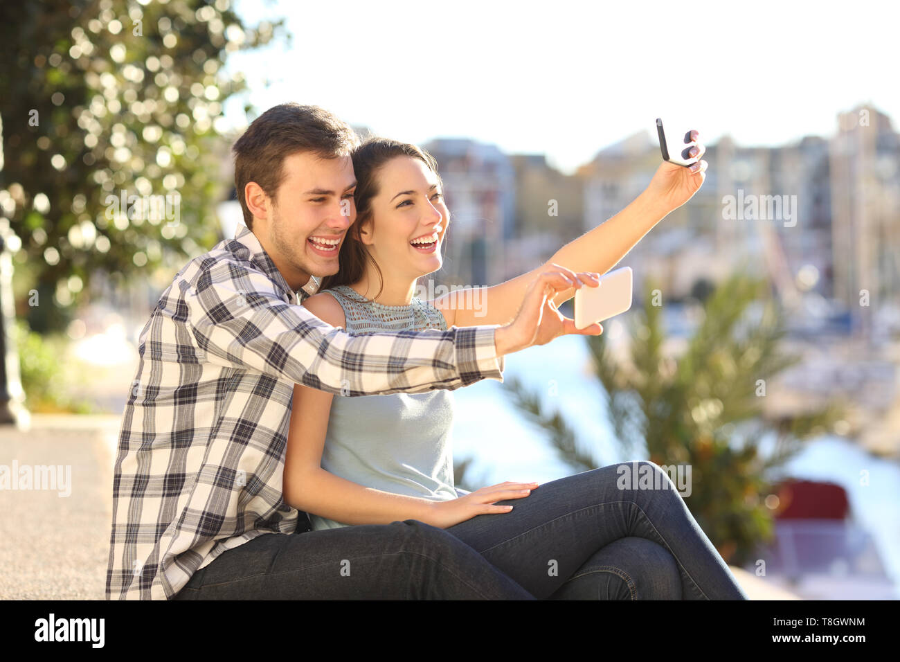 Happy couple taking selfies with their smart phones on summer vacation Stock Photo
