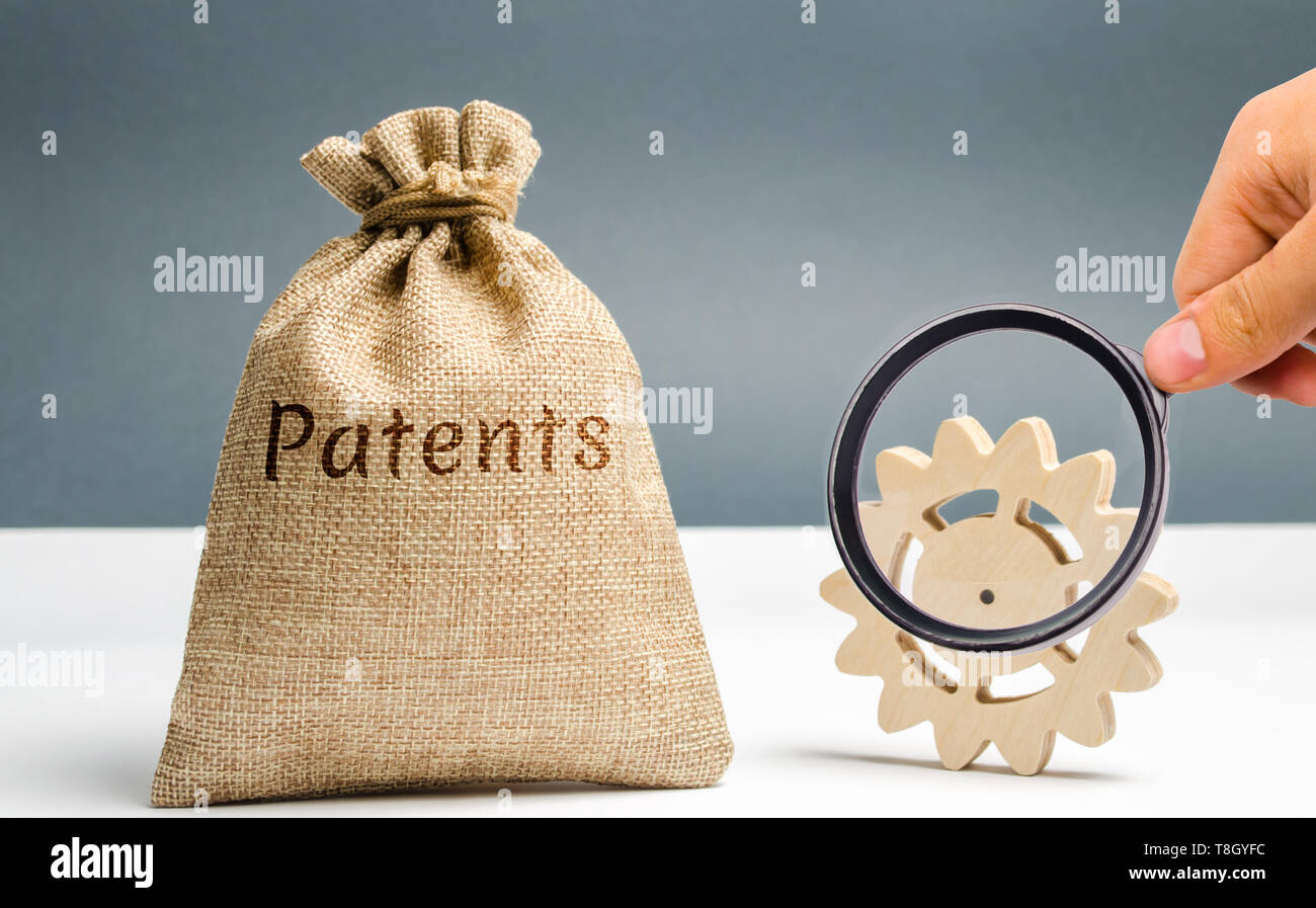 Money bag with the word Patents and a wooden gear. Registration of patents and copyright compliance. Licensing technology and scientific discoveries.  Stock Photo