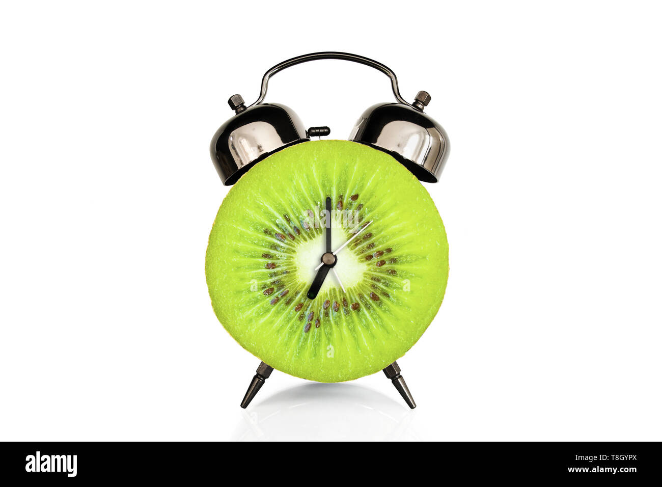 Kiwi slice on alarm clock, isolated on white background, fruit and vitamins diet at breakfast nutrition concept Stock Photo
