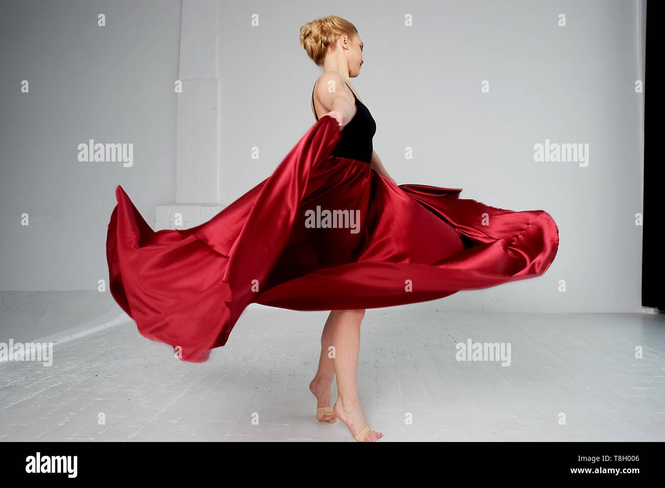 A gymnast in a dark top and a red silk skirt. The color of passion, of ...