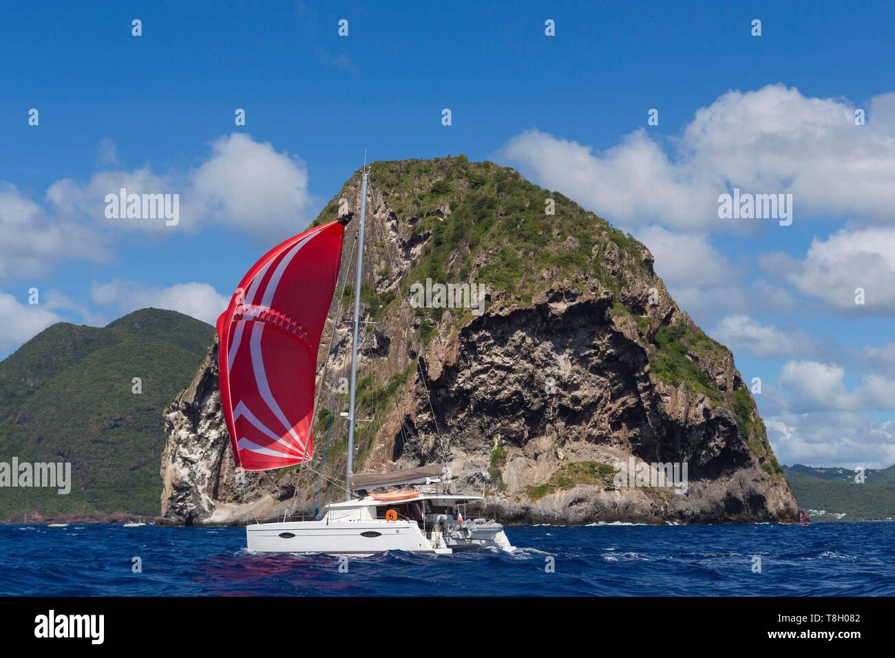 Martinique, Caribbean Sea diamond tip, desert island, diamond rock, foreground cruising catamaran sailing under red spinnaker Stock Photo