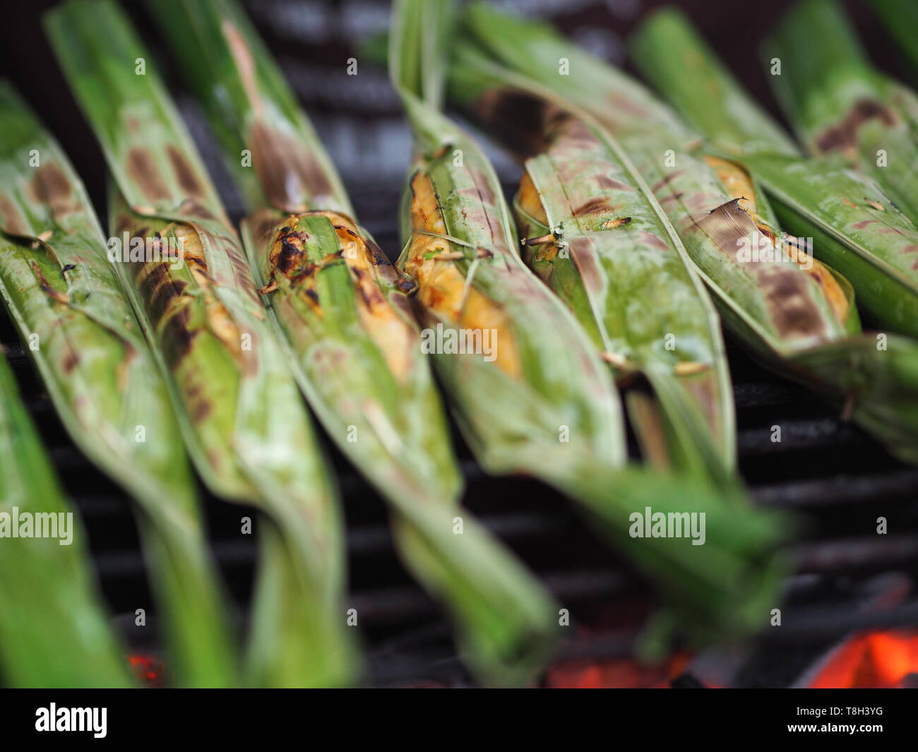 fried fish paste balls or fish cake in banana leaves grill on steel grille Stock Photo